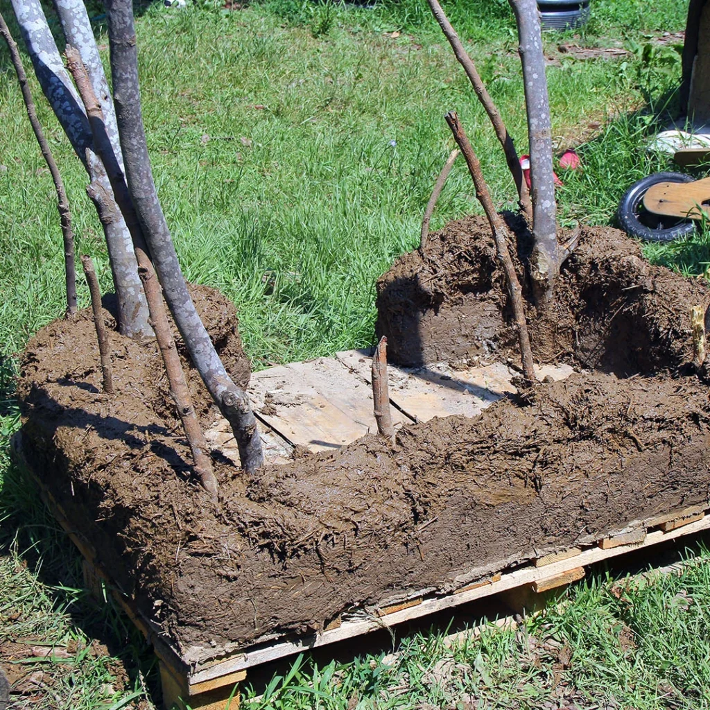 Die Lehm-Strohmischung bedeckt das Fundament des Hauses