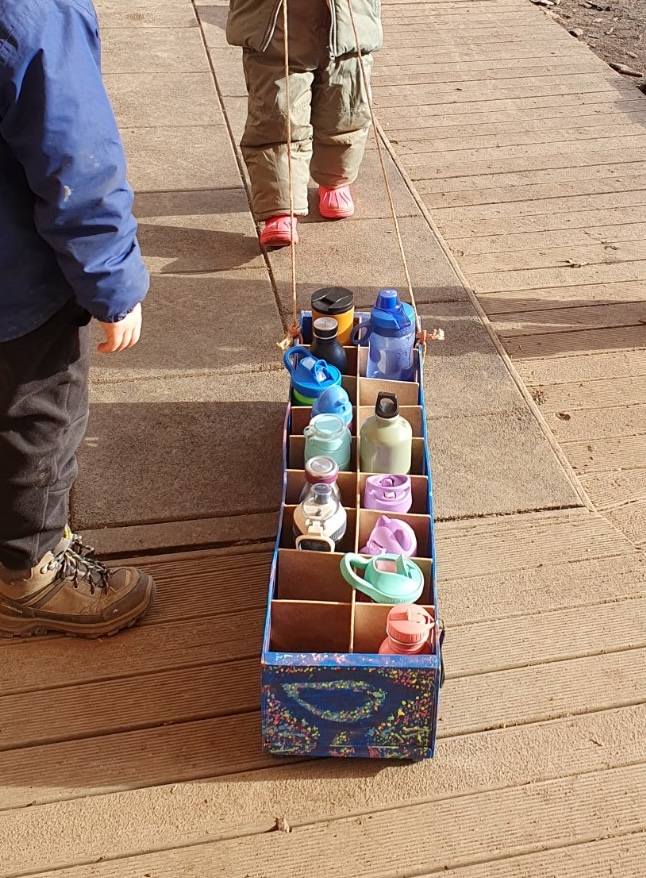 Kinder ziehen die fertig gebaute Wasserstation