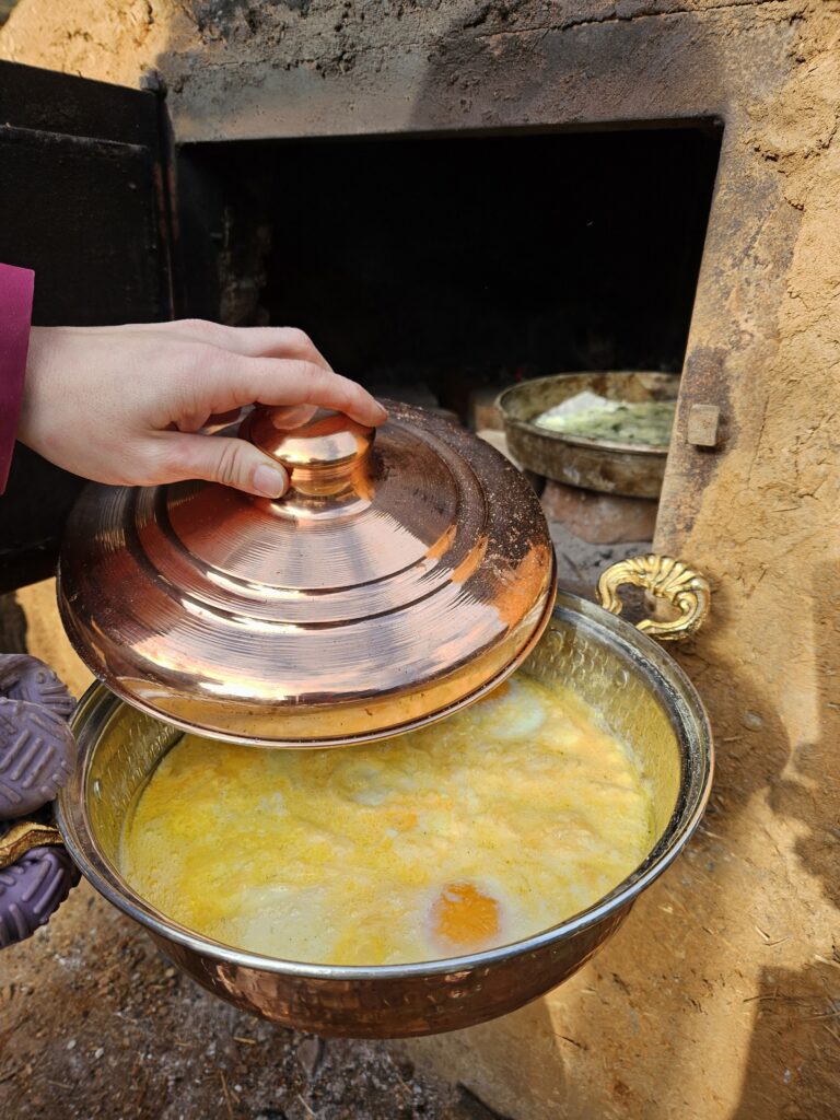 Rührei im Kupfertopf mit Deckel vor dem Erdofen