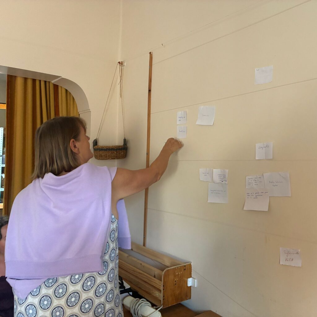 Regina heftet die im OSİ Team Seminar gesammelten Zielsetzungen an die Wand